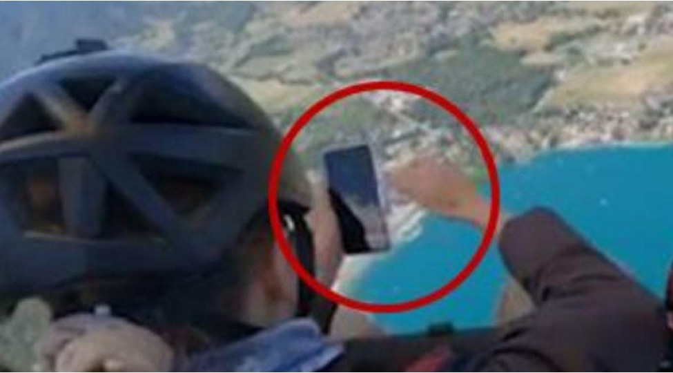 parashutle-tullanan-yashli-qadin-bahali-telefonunu-denize-dushurdu-video